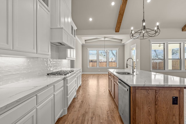 kitchen with appliances with stainless steel finishes, sink, a center island with sink, and white cabinets