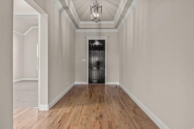 entryway featuring lofted ceiling, a notable chandelier, ornamental molding, and light wood-type flooring