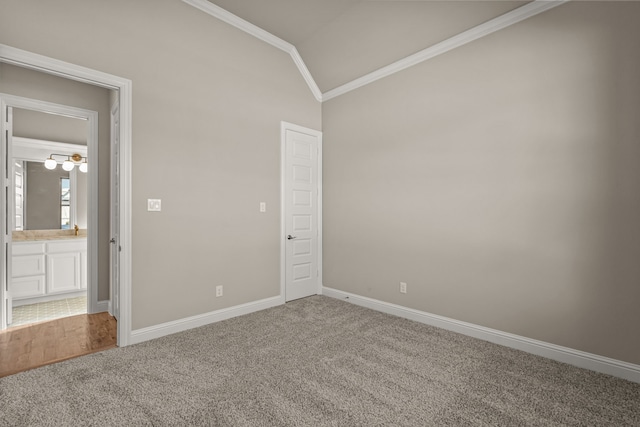 unfurnished room with crown molding, vaulted ceiling, and carpet