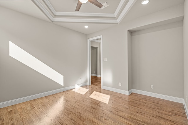 unfurnished room featuring crown molding, ceiling fan, a raised ceiling, and light hardwood / wood-style flooring