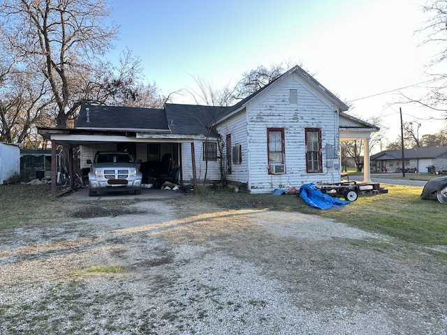 view of front facade with cooling unit and a carport