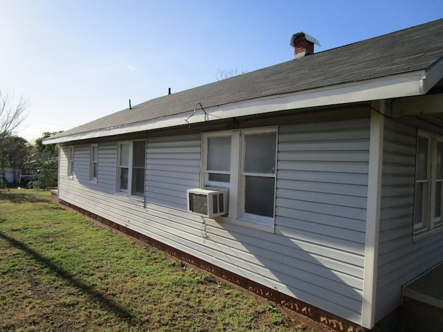 view of side of property featuring cooling unit and a yard