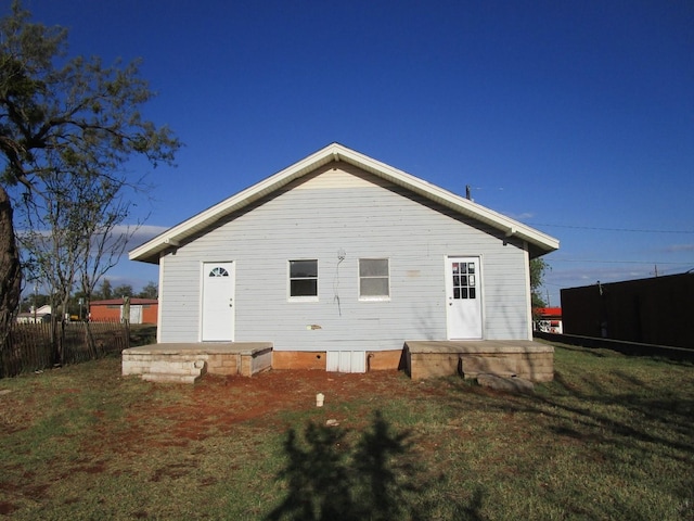 rear view of house featuring a lawn