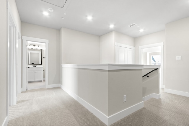 corridor with light carpet, visible vents, baseboards, an upstairs landing, and recessed lighting