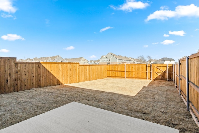 view of yard featuring a fenced backyard, a residential view, and a gate