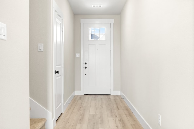 doorway with light wood-style floors, visible vents, stairway, and baseboards