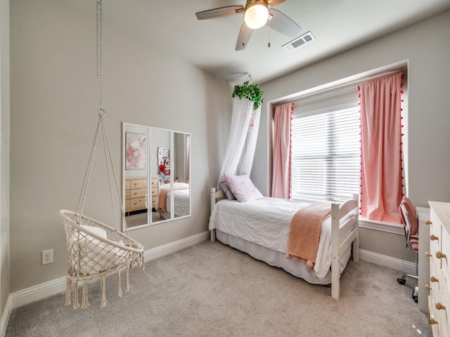 bedroom featuring ceiling fan, light colored carpet, and multiple windows