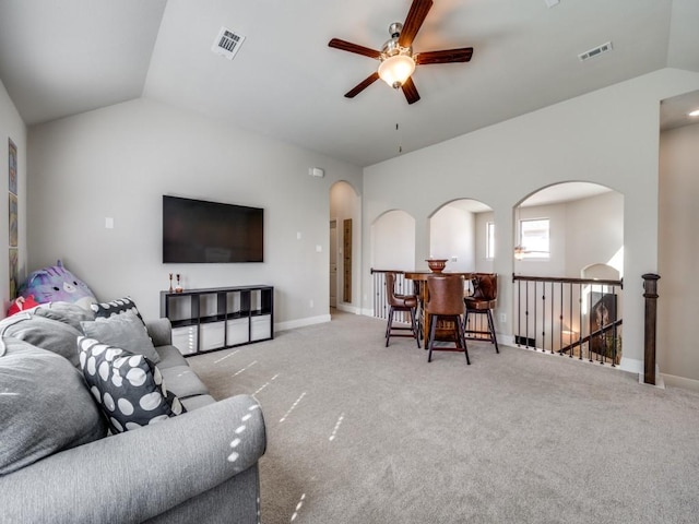 living room with lofted ceiling, ceiling fan, and light carpet