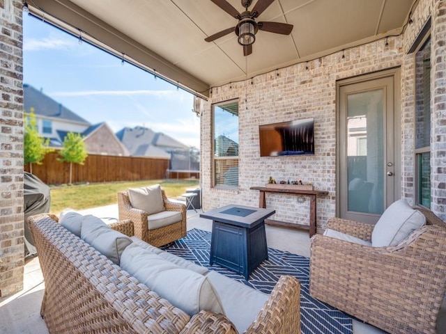 view of patio featuring ceiling fan and an outdoor living space with a fire pit