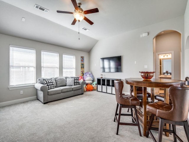 living room featuring carpet floors, ceiling fan, and vaulted ceiling