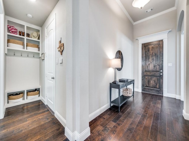 foyer entrance with crown molding and dark hardwood / wood-style floors