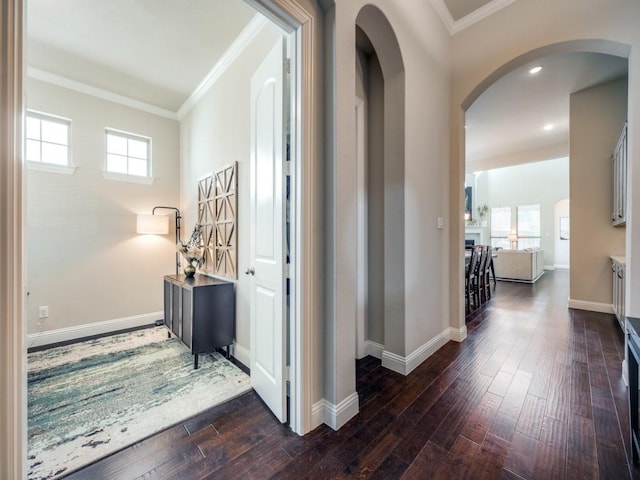 hall with dark wood-type flooring and ornamental molding