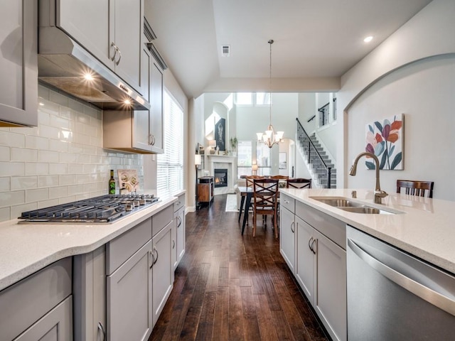 kitchen featuring stainless steel appliances, dark hardwood / wood-style floors, backsplash, decorative light fixtures, and sink