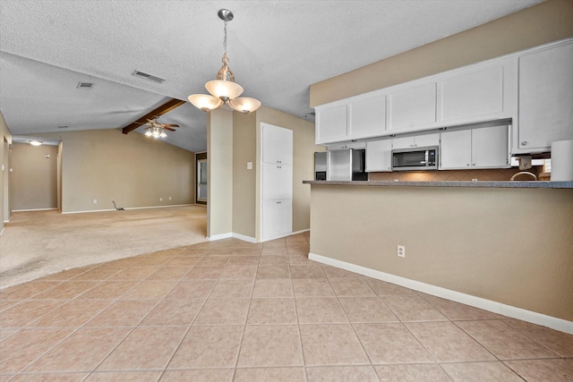 kitchen with ceiling fan, appliances with stainless steel finishes, white cabinetry, vaulted ceiling with beams, and decorative backsplash