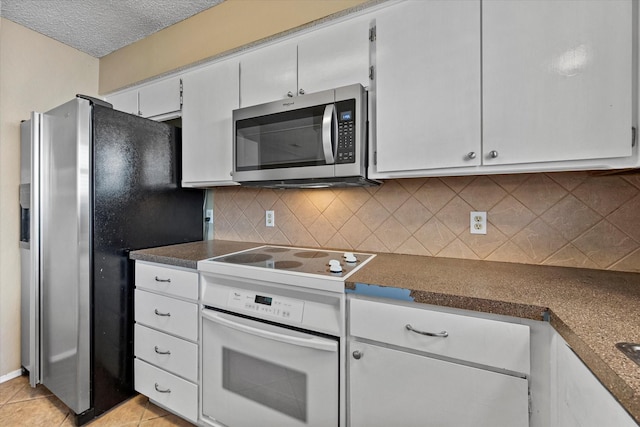 kitchen featuring a textured ceiling, light tile patterned floors, appliances with stainless steel finishes, white cabinets, and backsplash