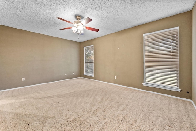 spare room featuring ceiling fan, carpet floors, and a textured ceiling