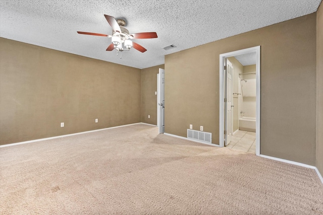 carpeted spare room featuring ceiling fan and a textured ceiling