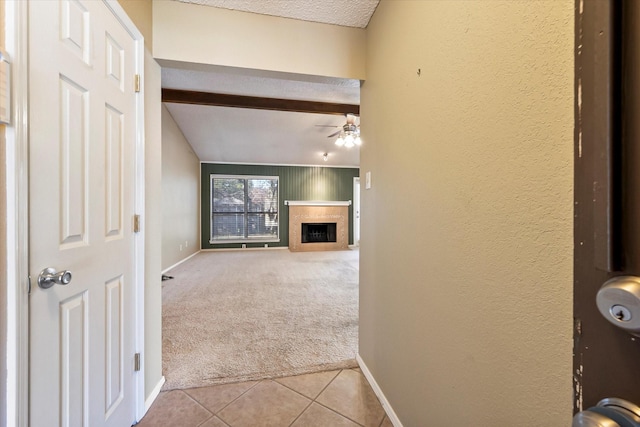 unfurnished living room with carpet, a healthy amount of sunlight, wooden walls, and a textured ceiling