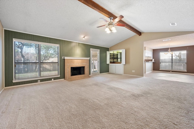 unfurnished living room featuring lofted ceiling with beams, ceiling fan, light colored carpet, and a textured ceiling