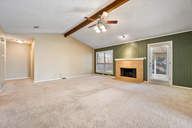 unfurnished living room with ceiling fan, vaulted ceiling with beams, light carpet, and a textured ceiling