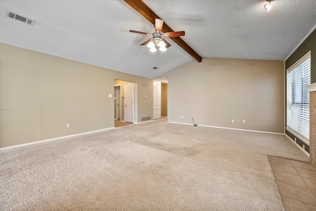 carpeted spare room featuring ceiling fan, a textured ceiling, and vaulted ceiling with beams