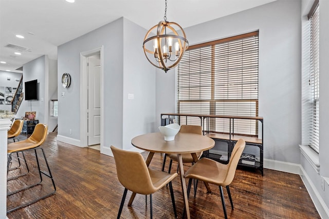 dining room with dark wood-type flooring and a chandelier