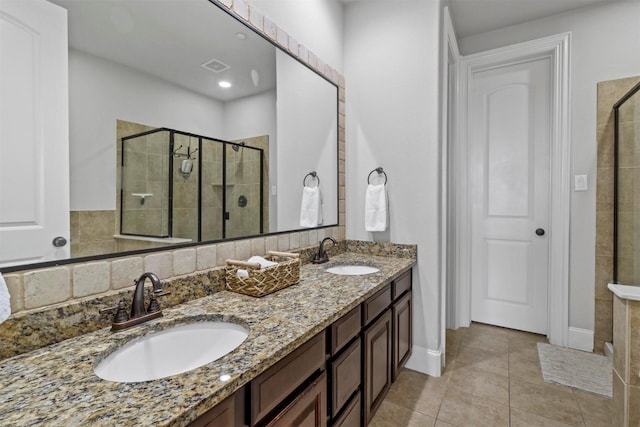 bathroom with tile patterned floors, a shower with shower door, and vanity