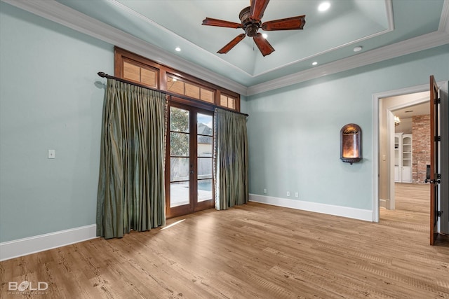 empty room featuring ceiling fan, french doors, a tray ceiling, and ornamental molding