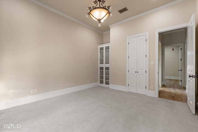 unfurnished bedroom featuring a closet, ornamental molding, and light colored carpet