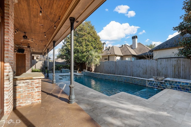 view of swimming pool with ceiling fan, pool water feature, and a patio