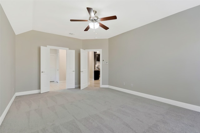 unfurnished bedroom with ceiling fan, light carpet, and vaulted ceiling