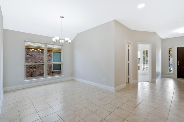 spare room with vaulted ceiling, an inviting chandelier, and light tile patterned flooring