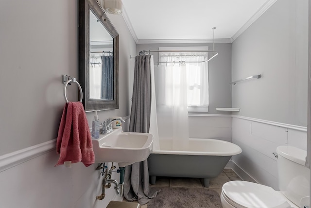 full bathroom featuring sink, toilet, crown molding, and shower / tub combo with curtain