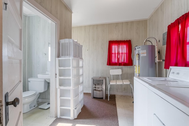 washroom featuring heating unit, washer / dryer, and water heater