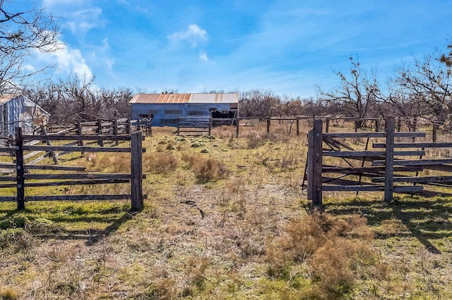 view of gate with an outbuilding and a rural view