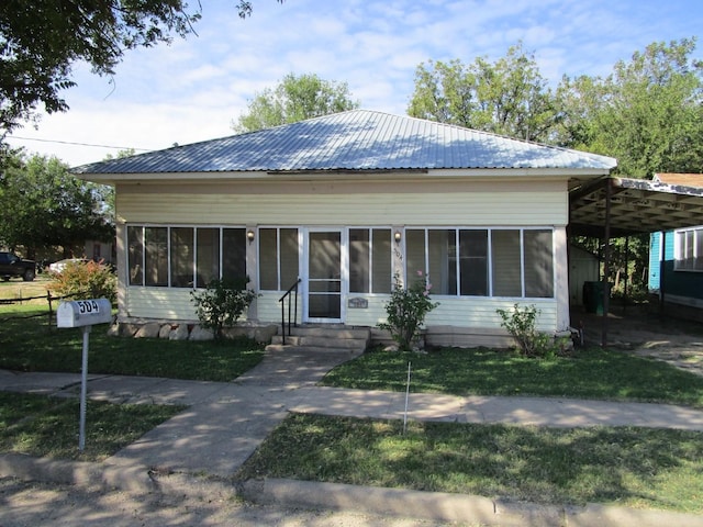 view of front of home with a front lawn and a sunroom