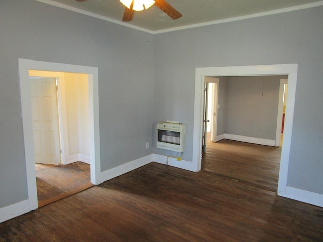 spare room with heating unit, ceiling fan, dark wood-type flooring, and crown molding