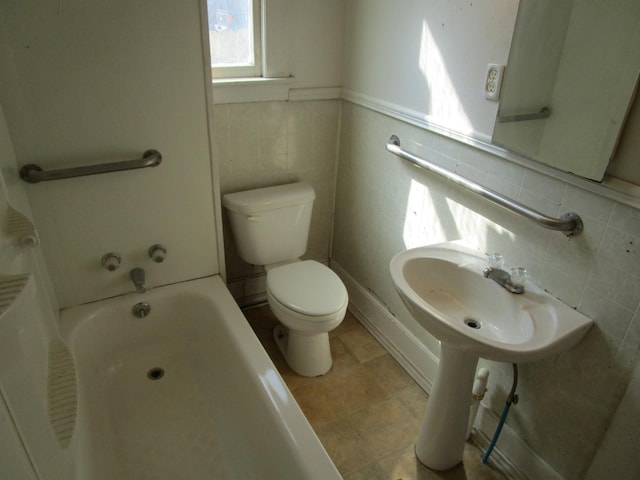 bathroom with toilet, a bathing tub, and tile walls