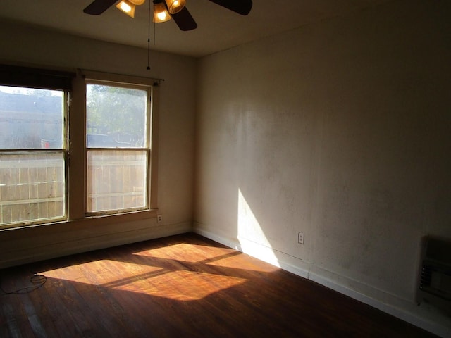 spare room with ceiling fan, heating unit, and light hardwood / wood-style flooring