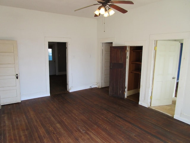 unfurnished bedroom with ceiling fan and dark wood-type flooring