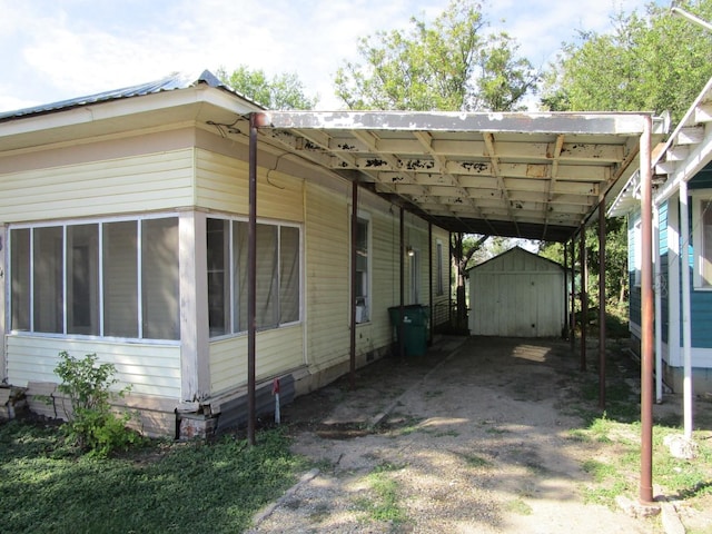 view of side of home featuring a storage unit and a carport