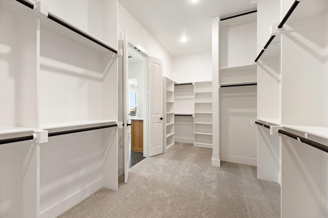 walk in closet featuring light colored carpet