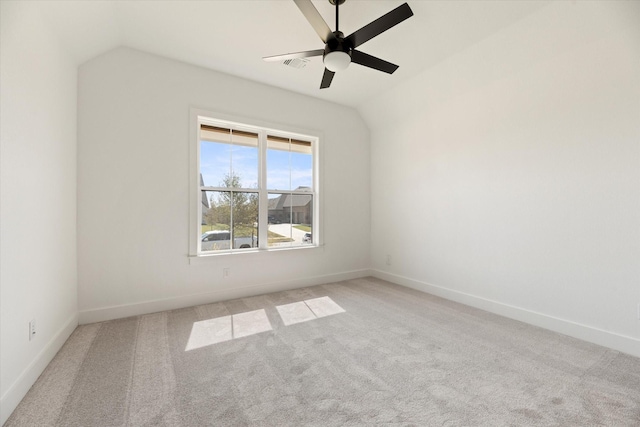 empty room with ceiling fan, light colored carpet, and vaulted ceiling