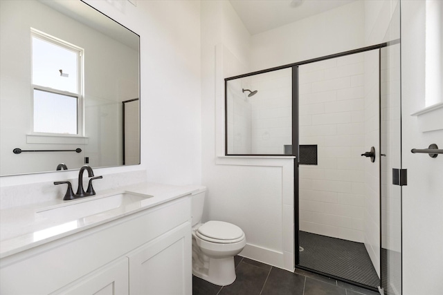 bathroom featuring toilet, vanity, tile patterned flooring, and a shower with shower door