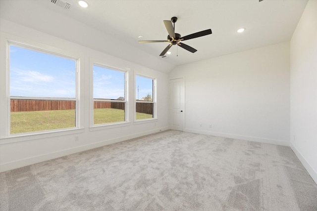 unfurnished room with light carpet, vaulted ceiling, and plenty of natural light