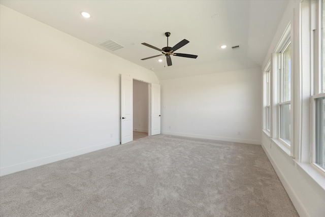 carpeted empty room with ceiling fan and vaulted ceiling