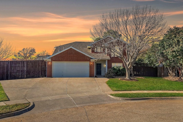 view of front of house with a garage and a yard