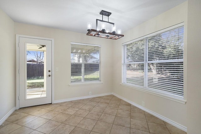 unfurnished dining area featuring light tile patterned floors and a chandelier