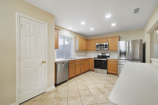 kitchen with light tile patterned floors, appliances with stainless steel finishes, and sink