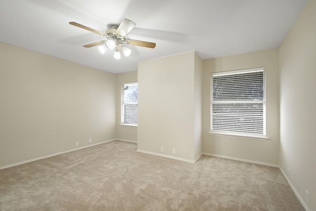 carpeted spare room featuring ceiling fan